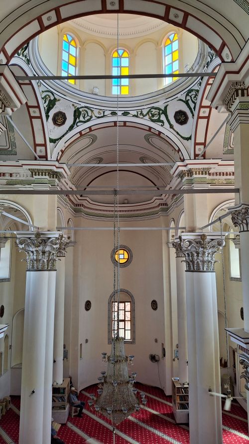 Free Stunning view of a mosque's ornate interior with columns and stained glass windows. Stock Photo