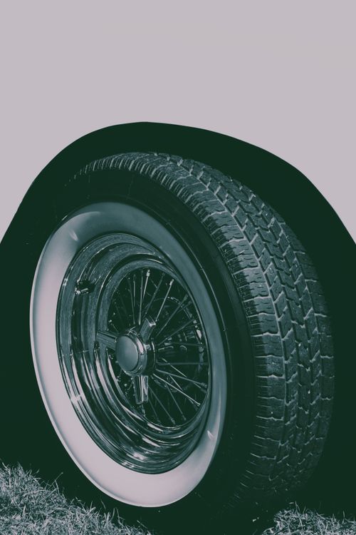 Free Close-up of a chrome-spoked vintage car wheel with whitewall tires, showcasing retro automotive design. Stock Photo