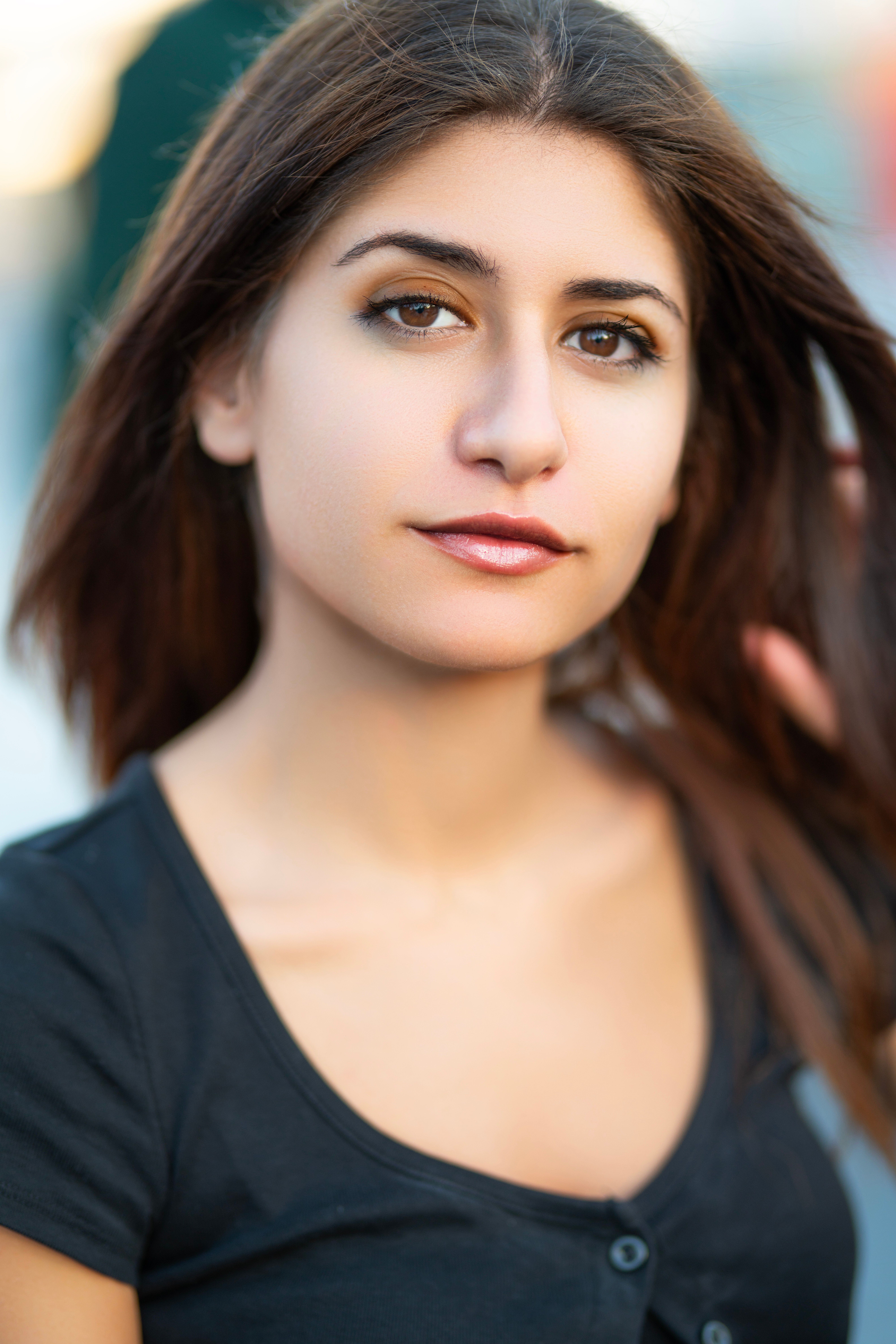 Close-up portrait of a young woman with long brown hair, outdoors in Istanbul.