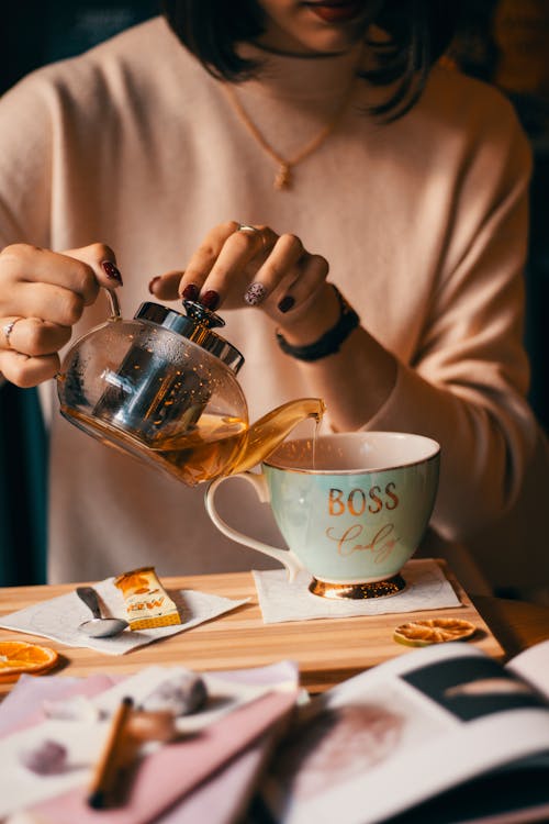 Woman Pouring Tea into Mug