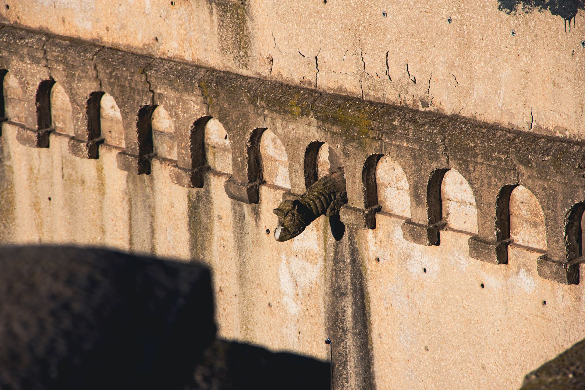 Close-up of an ancient fort's stone walls with intricate drainage spouts.