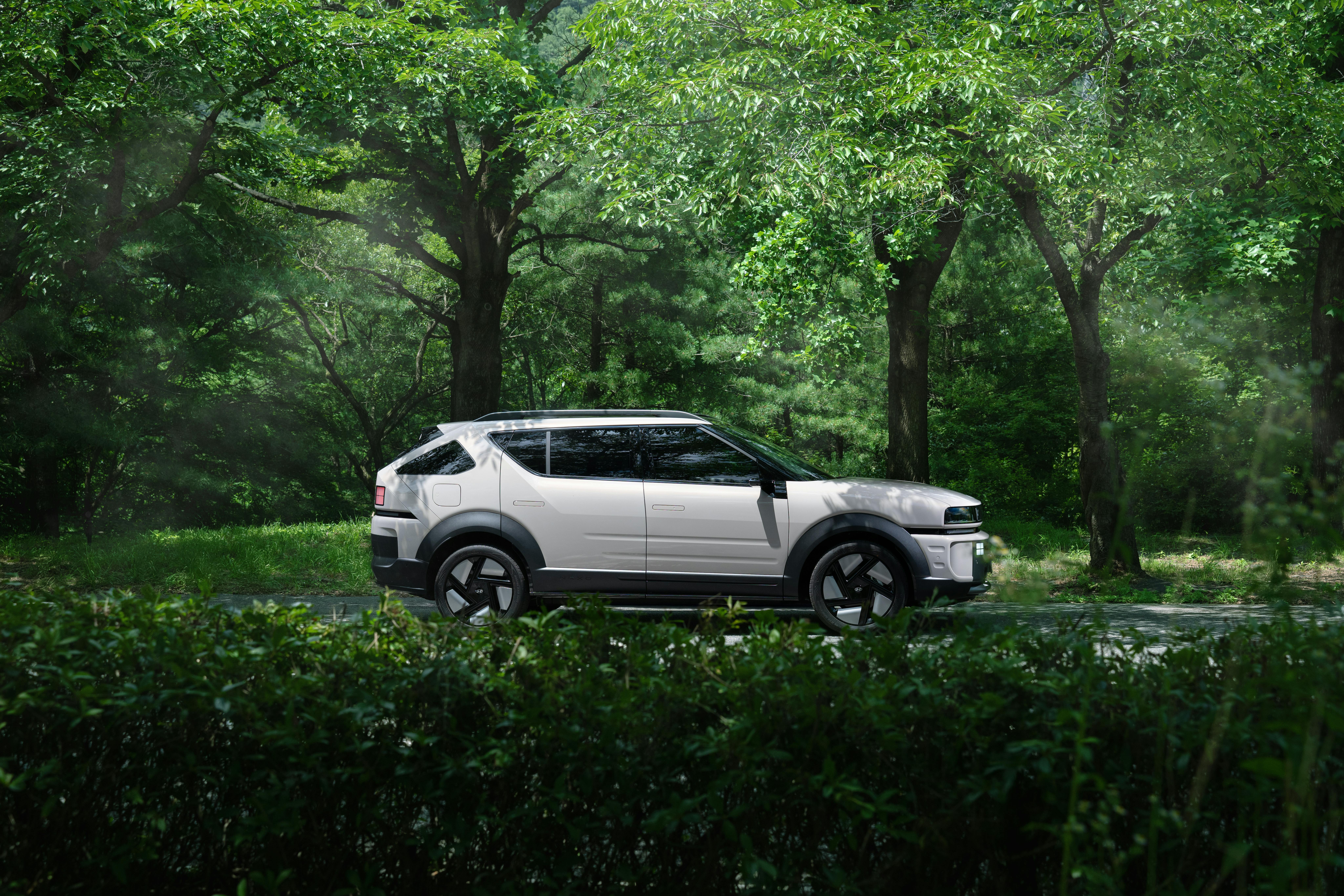 A modern electric SUV parked in a serene forest, blending nature and technology.