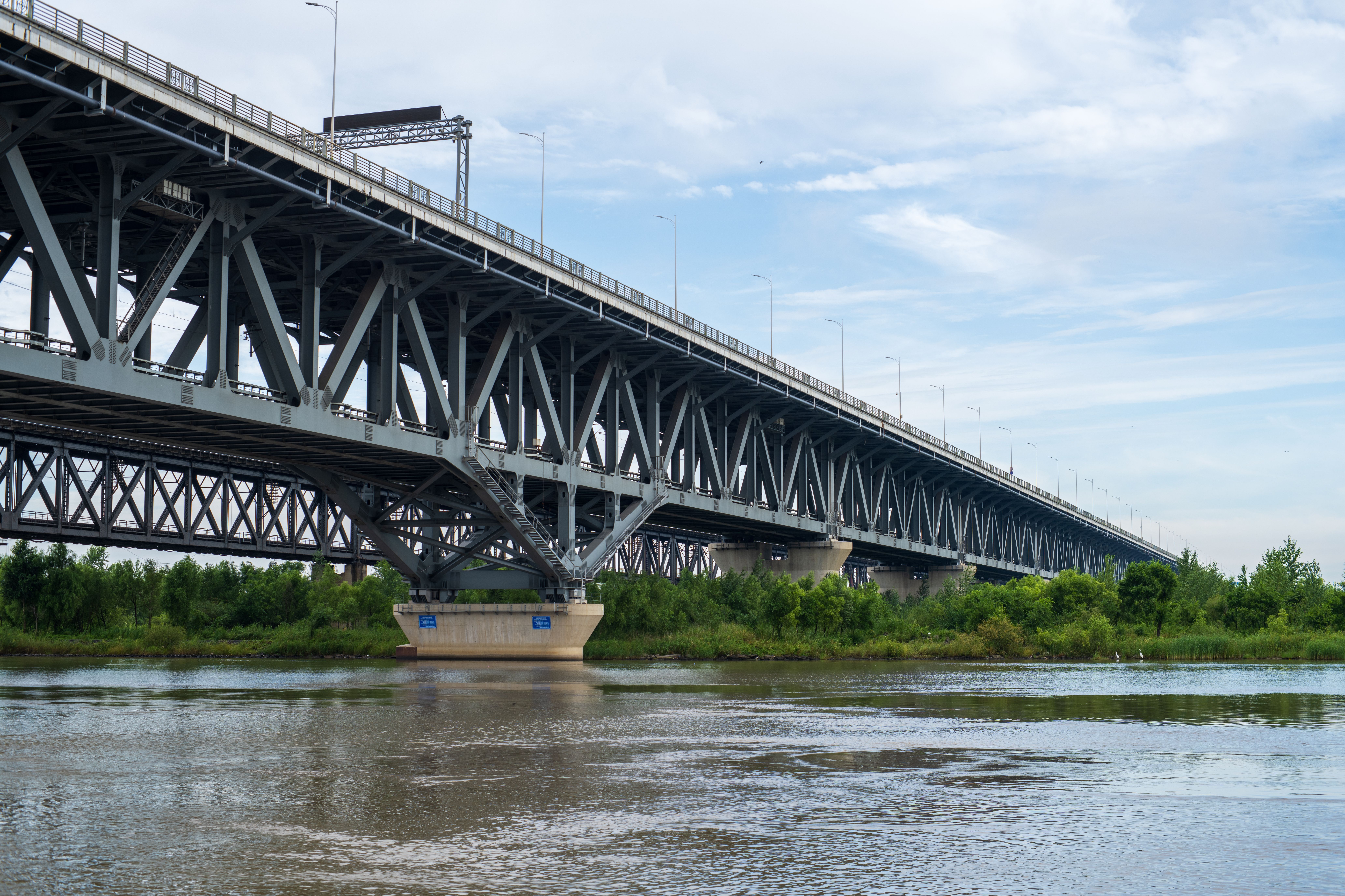 Steel Bridge Spanning Peaceful River Under Blue Sky · Free Stock Photo
