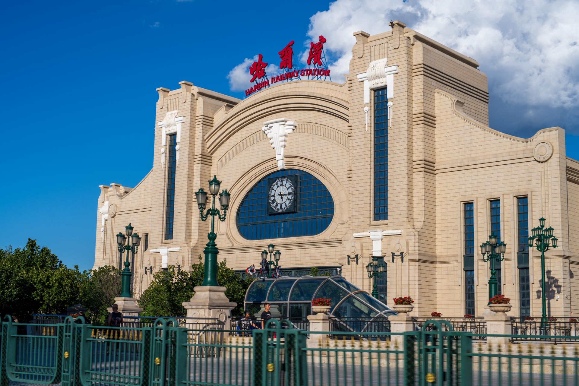 Stunning view of the historic Harbin Railway Station with its classical architecture under a bright blue sky.