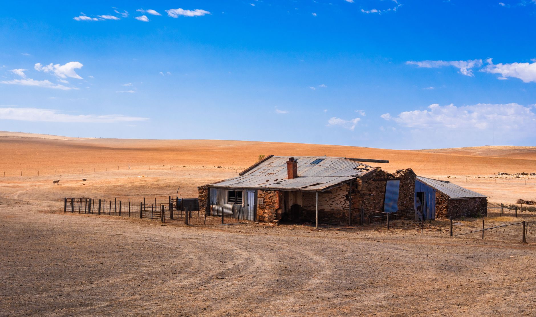Verlaten rustiek huis in de uitgestrekte outback van Zuid-Australië onder een stralendblauwe hemel.