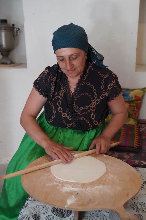 Free Middle-aged woman making homemade flatbread in a cozy kitchen. Stock Photo
