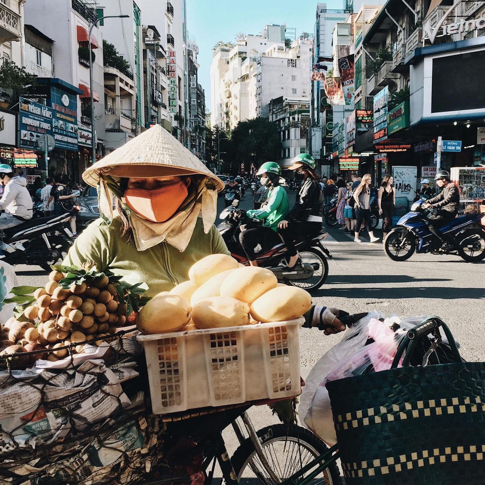Vietnamese street vendor serving customers in a busy Ho Chi Minh City market
