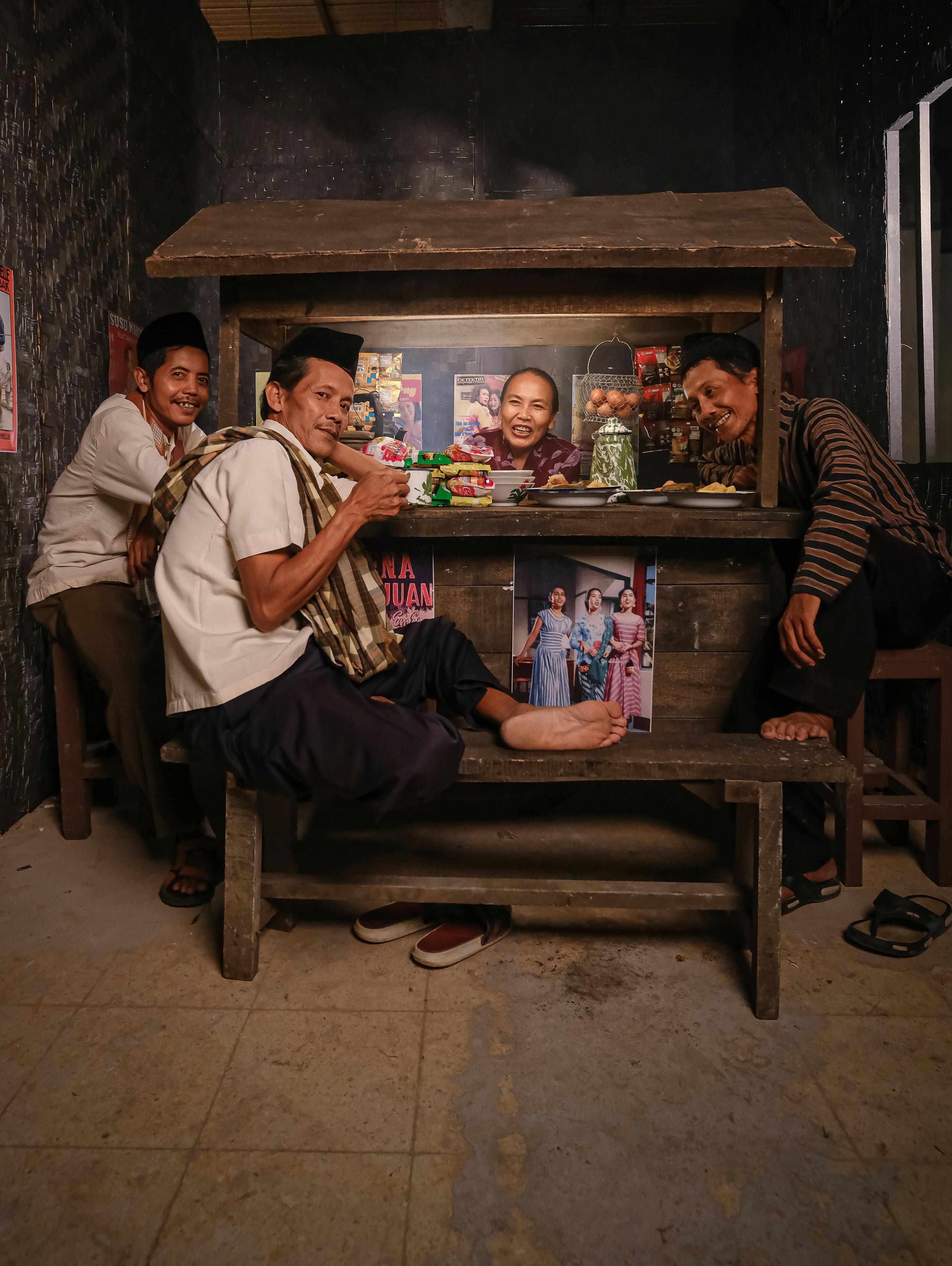 Locals eating nasi campur at a traditional Balinese warung with rattan stools and an open kitchen