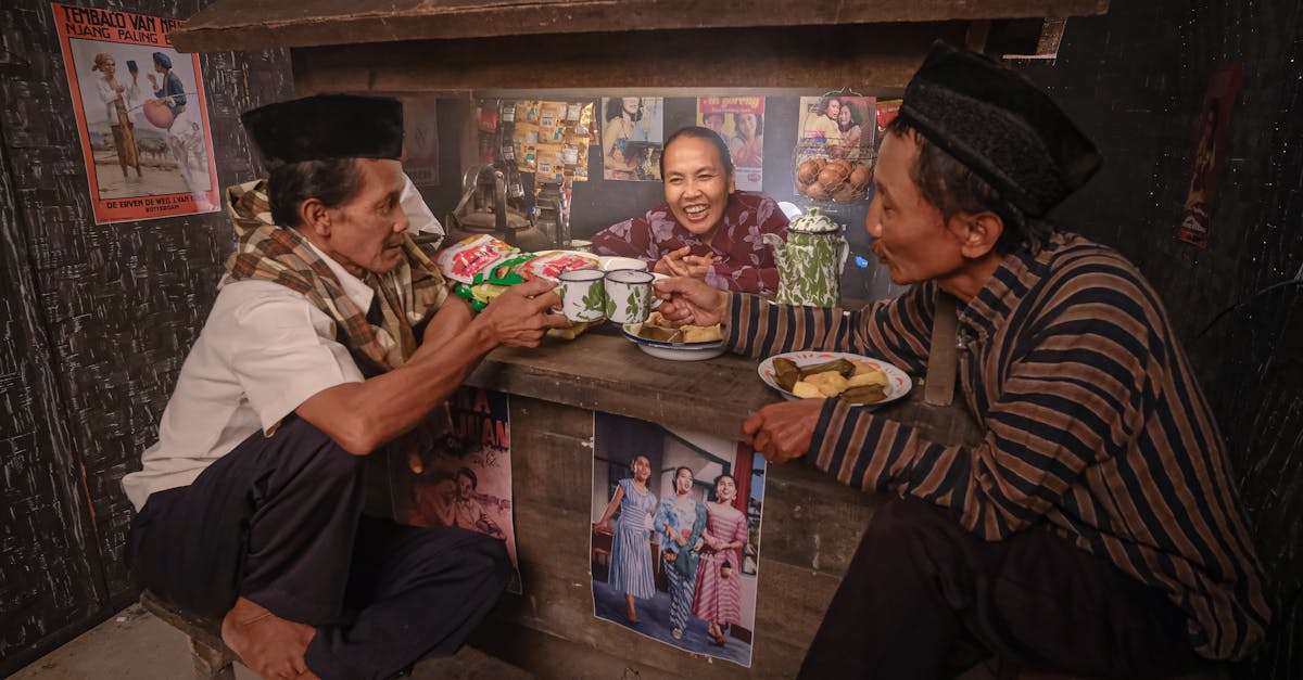 Group of Indonesian people laughing and sharing stories over coffee and traditional snacks at a cozy Warung Kopi (coffee shop), reflecting the warmth of community, friendship, and cultural...