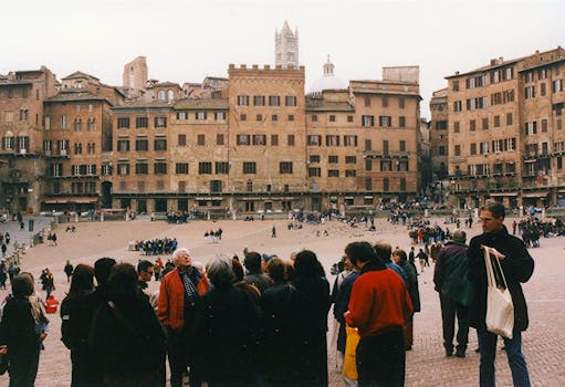Historic Piazza del Campo in Siena with a bustling crowd and medieval architecture.