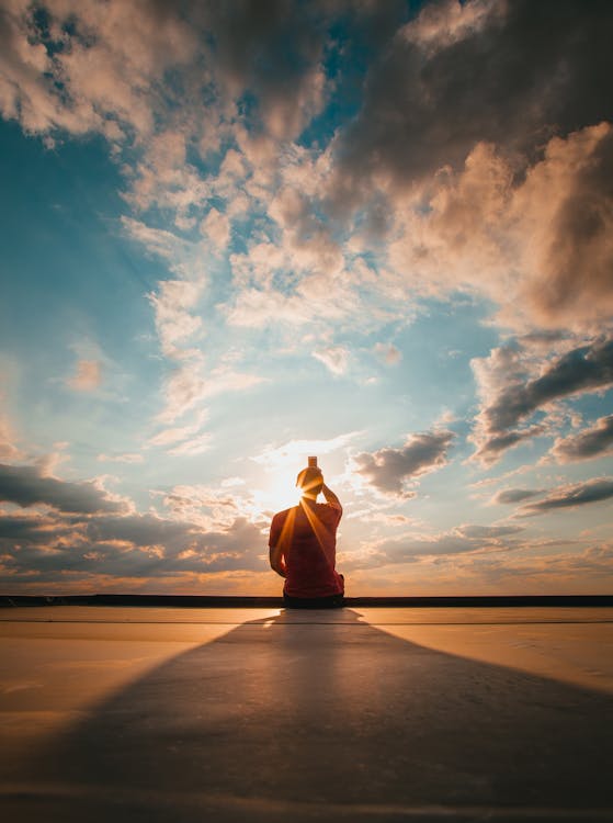 Free Photo Of Person Sitting During Golden Hour Stock Photo