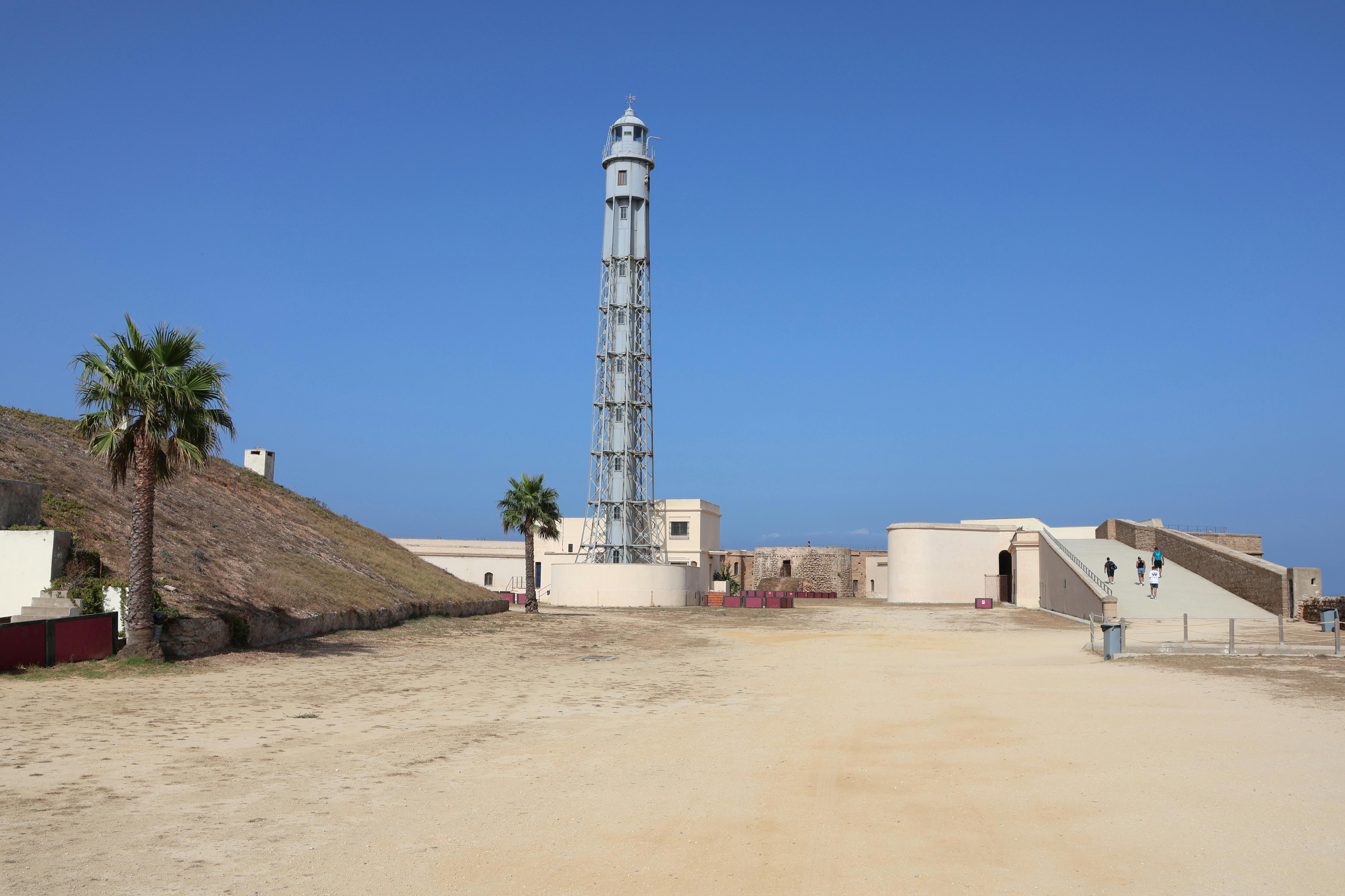 Lighthouse architecture of Torres Faro de Cádiz, Andalusia. Iconic tower by the coast under a clear blue sky.
