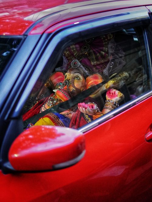 Free Vibrant Ganapati idol clothed in traditional attire inside a red car in Kolkata. Stock Photo