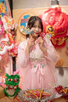 Young woman in pink traditional attire with colorful festive decorations, perfect for cultural events.