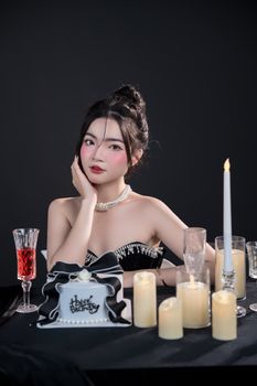 Stylish portrait of a woman celebrating her birthday with cake, candles, and wine.