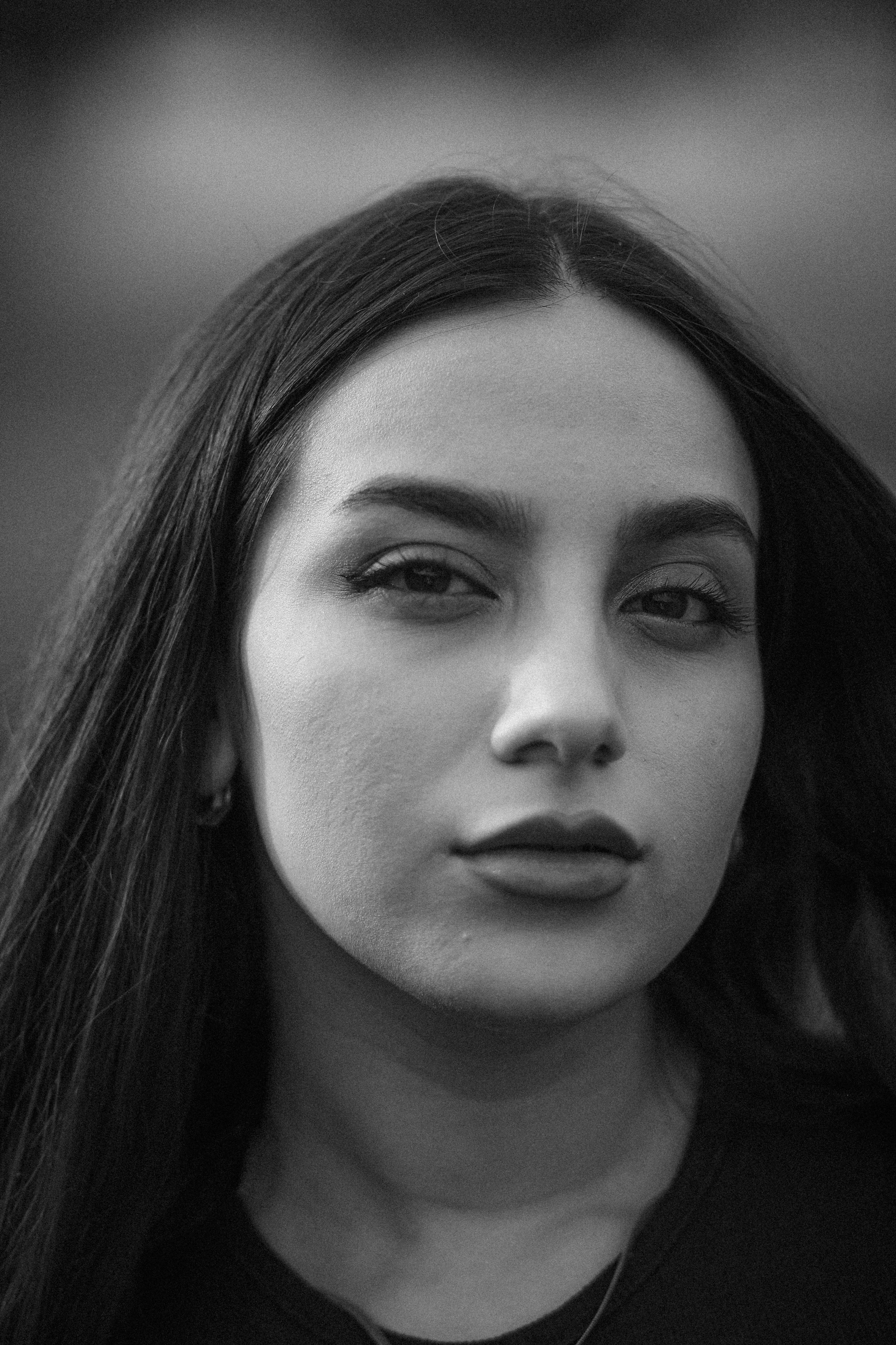 Gratis Splendido ritratto in bianco e nero di una giovane donna all'aperto, che mette in risalto eleganza e compostezza. Foto a disposizione