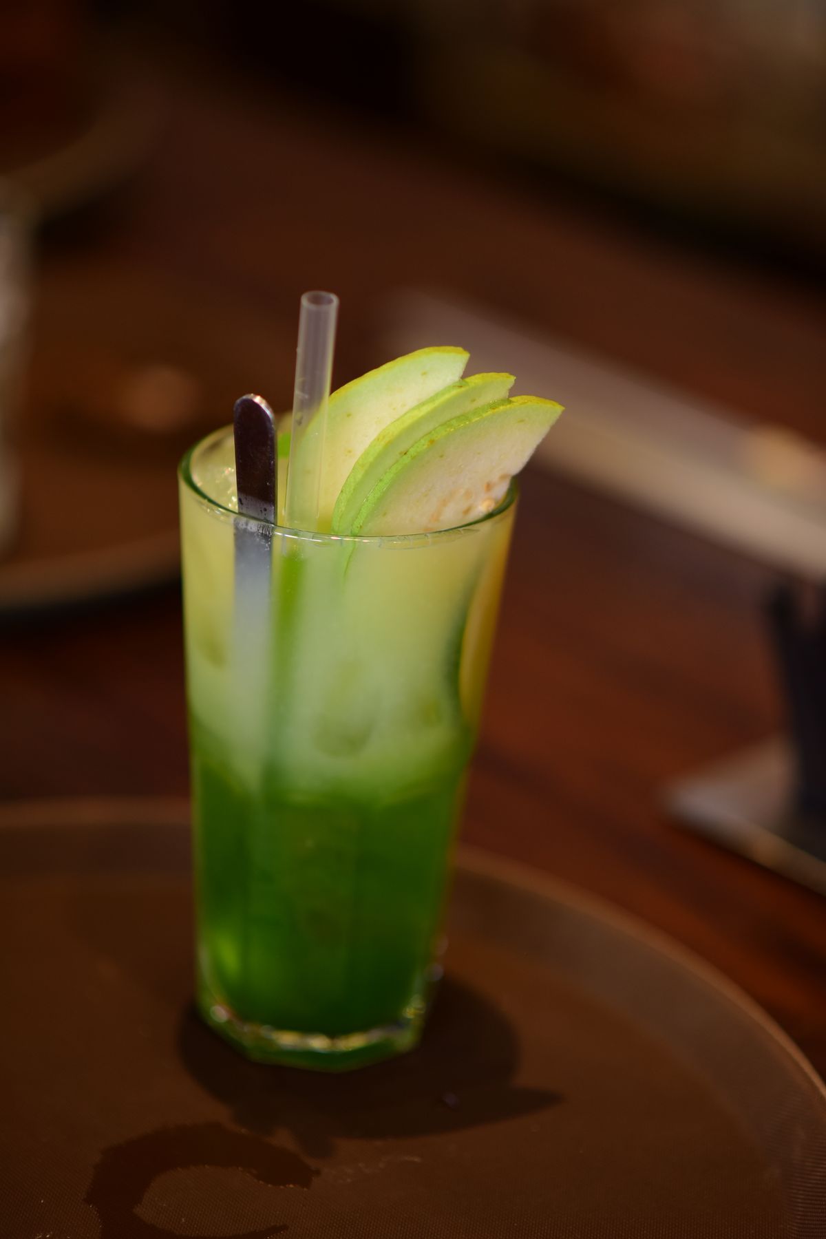 Green apple mocktail garnished with apple slices and ice
