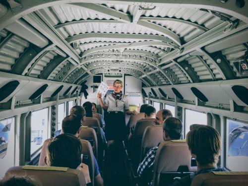 Free Inside a vintage aircraft, a flight attendant gives safety instructions to passengers. Stock Photo