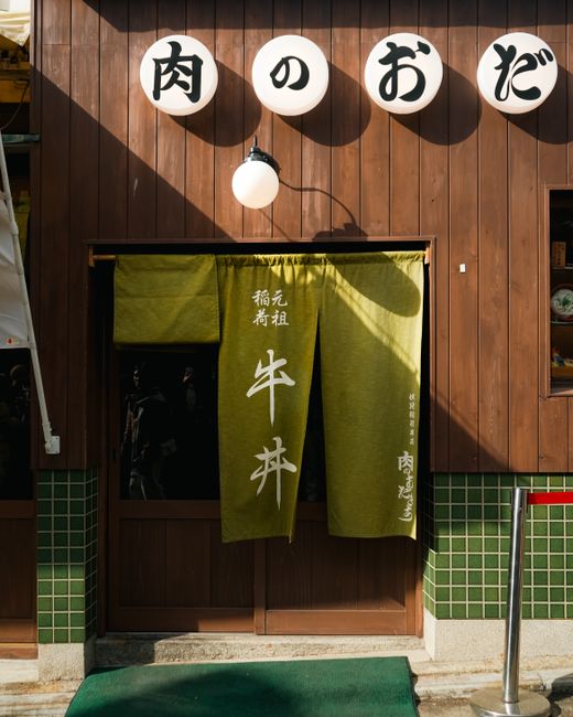 Wooden storefront with noren curtain in Japan, highlighting cultural aesthetics in vibrant street setting.