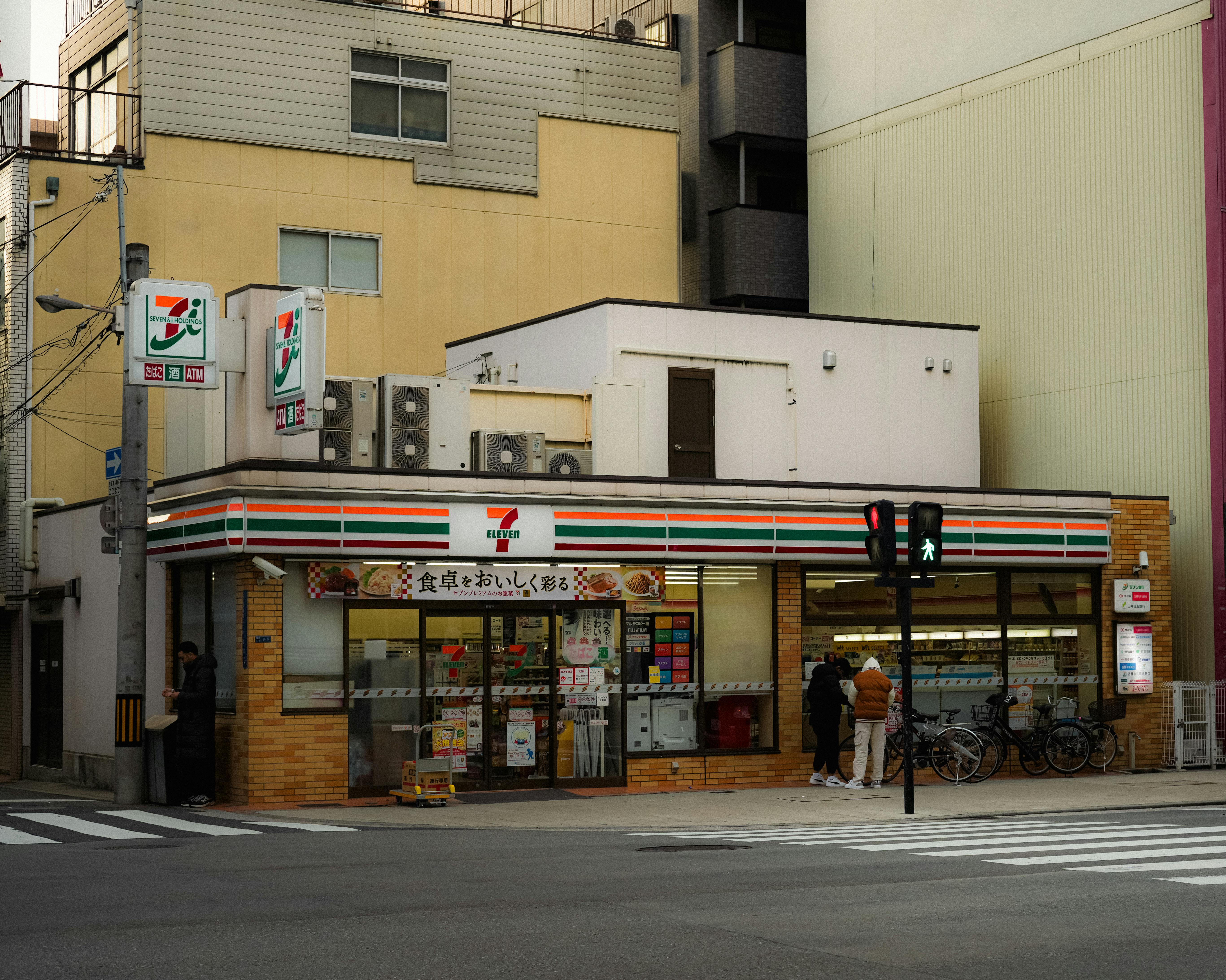 Candid street photo of a 7-Eleven convenience store in Japan.