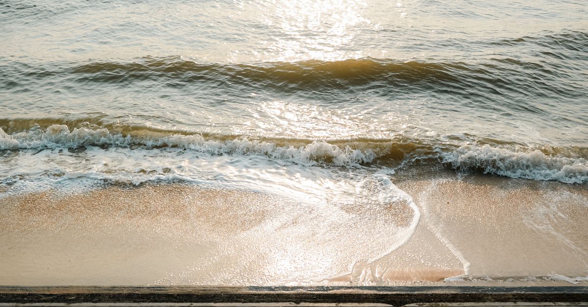 A peaceful Thai beach with gentle waves at golden hour