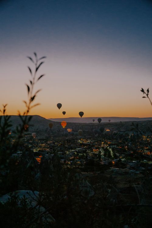 Free Breathtaking view of hot air balloons floating at dawn over Cappadocia's unique landscape. Stock Photo