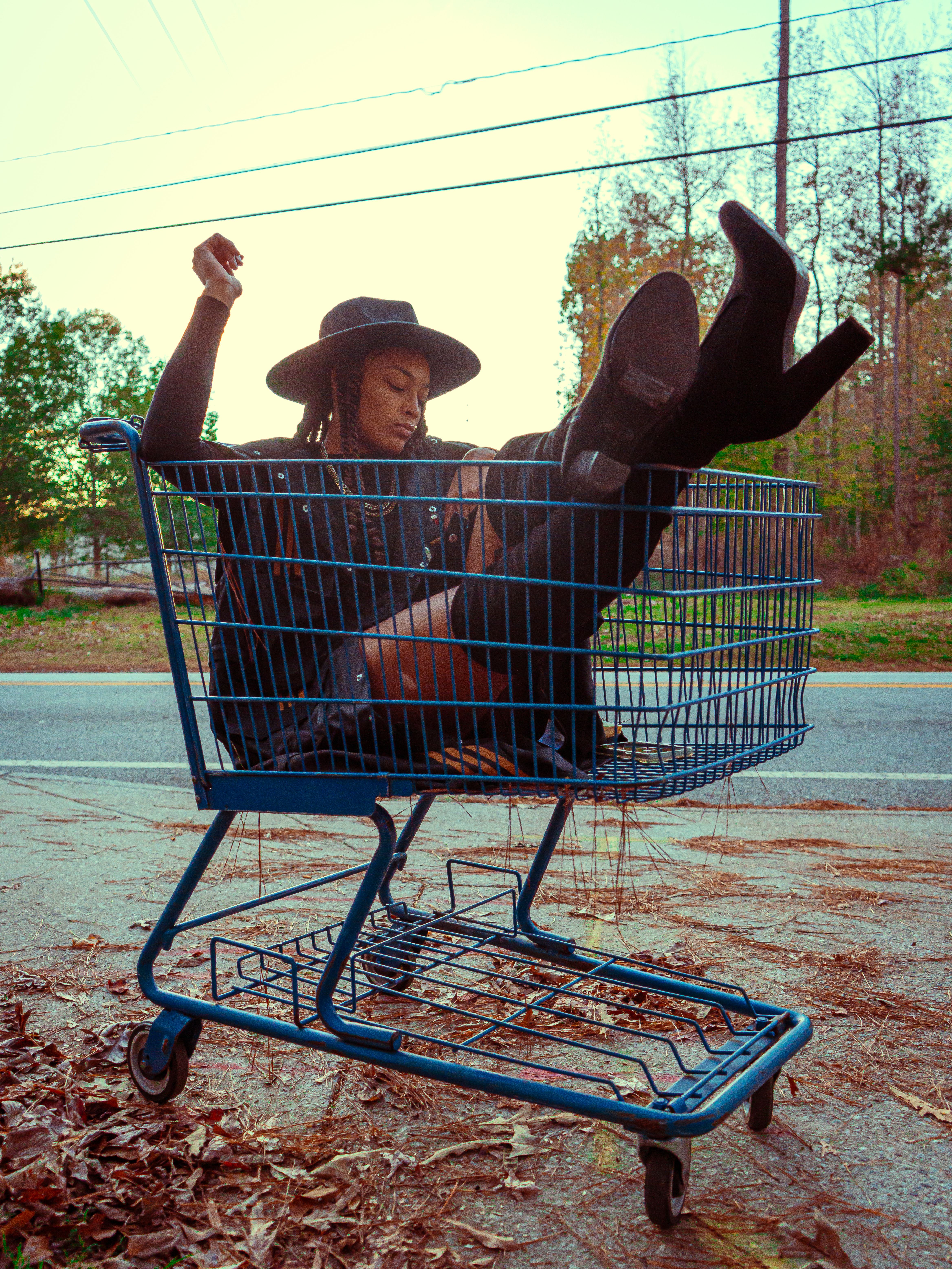 Stylish woman in a shopping cart outdoors, showcasing bold fashion in Atlanta.