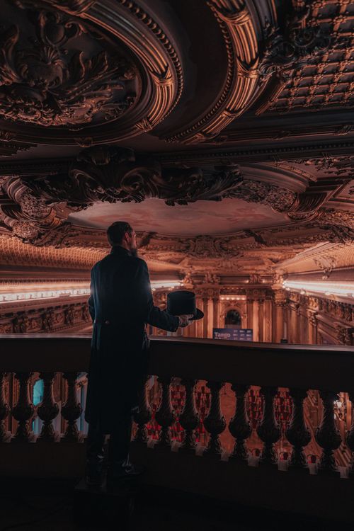 Free A person in formal wear stands in an opulent, historic hall, admiring intricate ceilings. Stock Photo