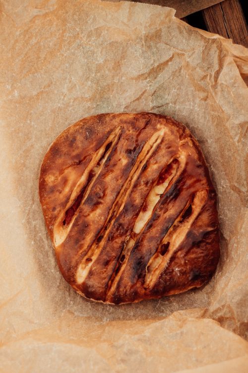 Free Crispy homemade white bread with deep slashes, baked to perfection on parchment. Stock Photo