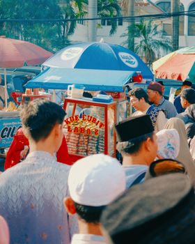 Vibrant street market during Eid in Jakarta featuring traditional Islamic clothing and community gathering.