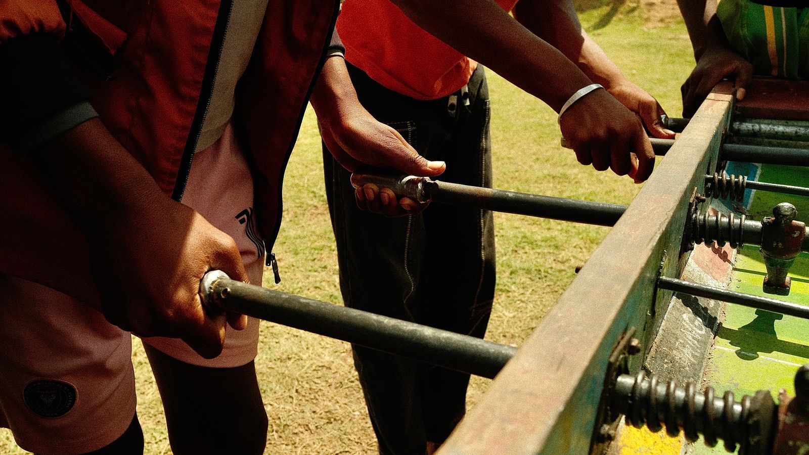 Young adults playing outdoor foosball game, Namibia