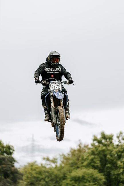 Thrilling motocross action with a rider soaring through the sky on a dirt bike.