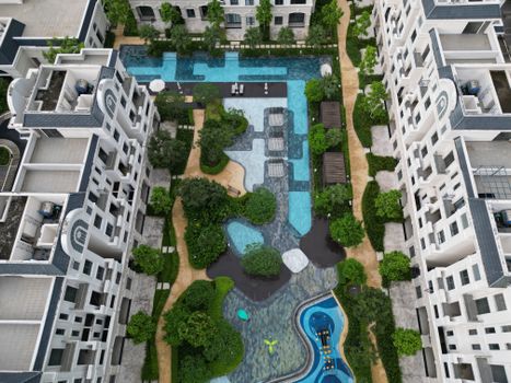 Aerial shot of a modern resort pool surrounded by greenery in Đồng Nai, Vietnam, highlighting the architectural design.