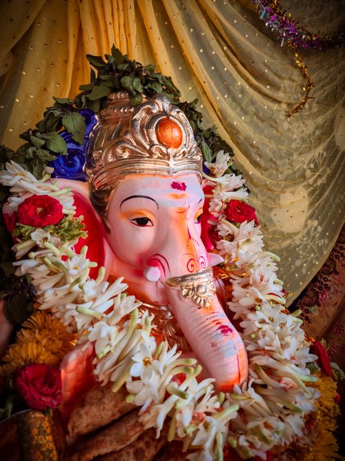 Free Beautifully adorned Lord Ganesha idol with colorful flowers during Ganesh Chaturthi festival. Stock Photo