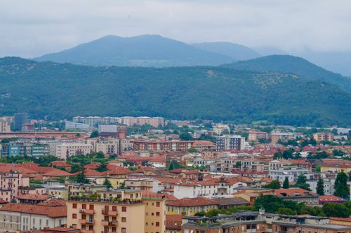Free Scenic aerial view of an Italian city with mountains in the backdrop. Stock Photo