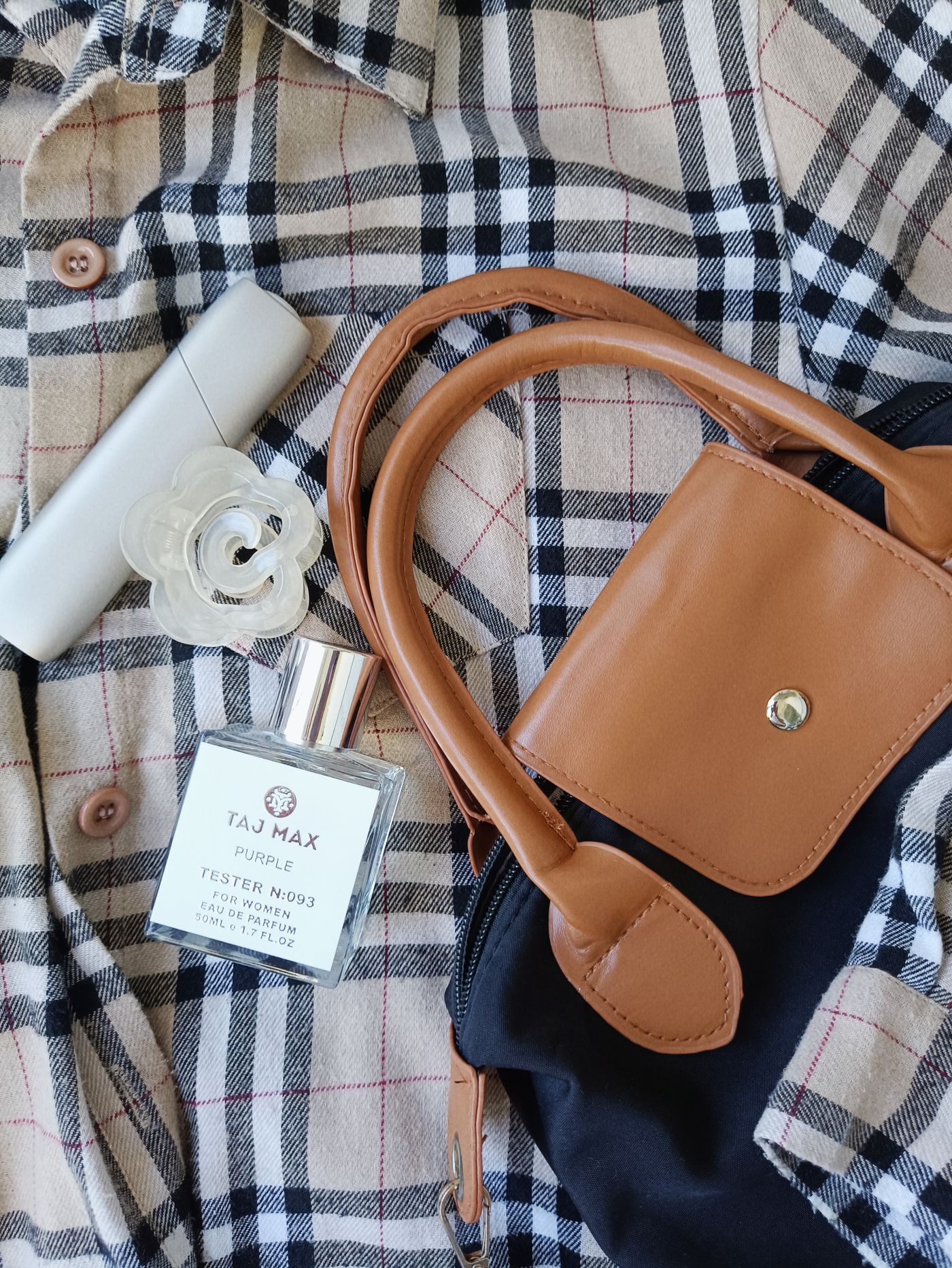 Plaid shirt and fashion accessories arranged in a clean flat lay without people