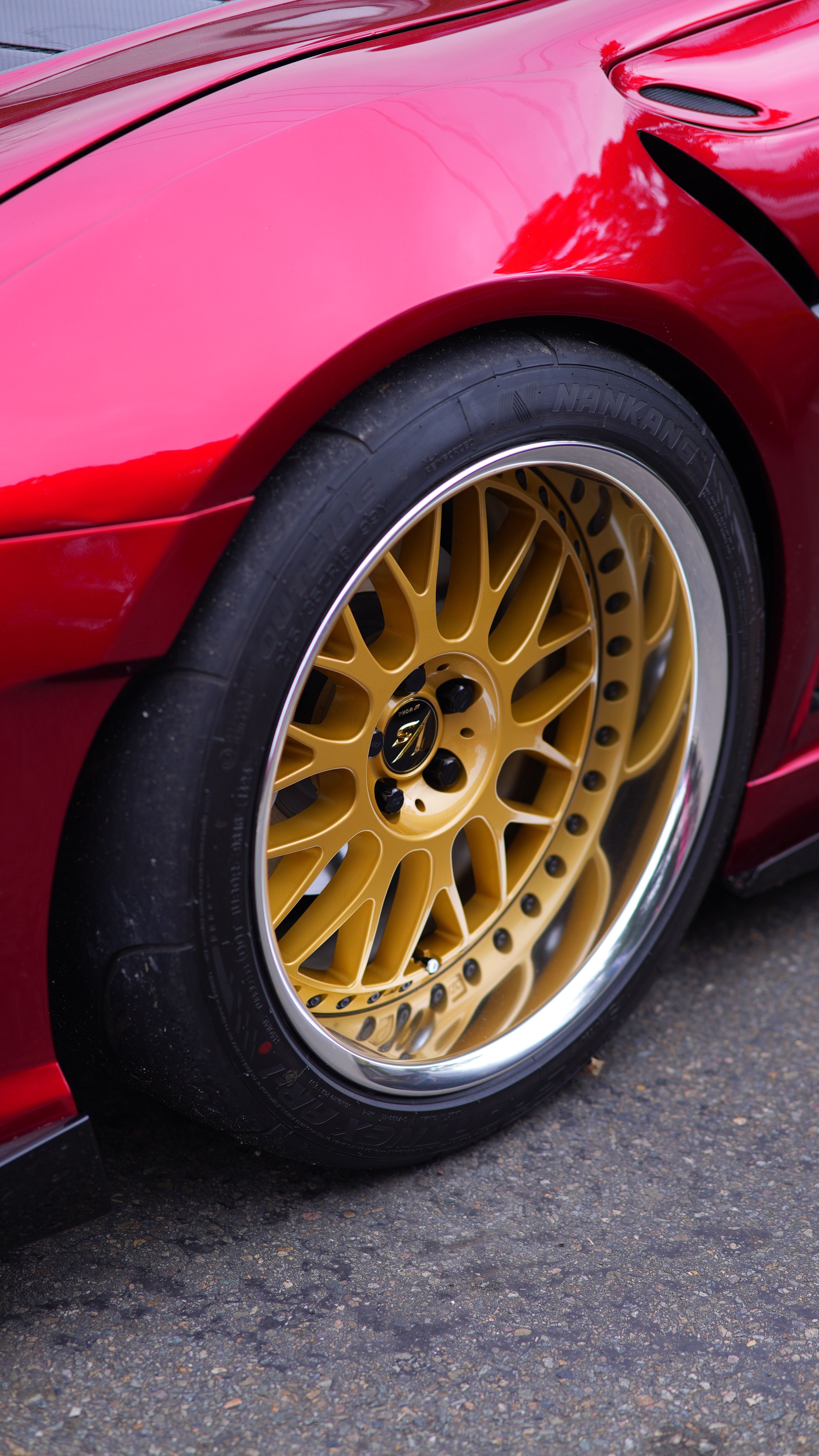 Close-Up of Red Sports Car with Gold Alloy Wheel · Free Stock Photo