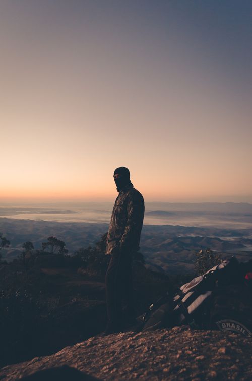 Free Silhouette of a man standing on a mountain peak during a sunset, capturing the beauty of an outdoor adventure. Stock Photo