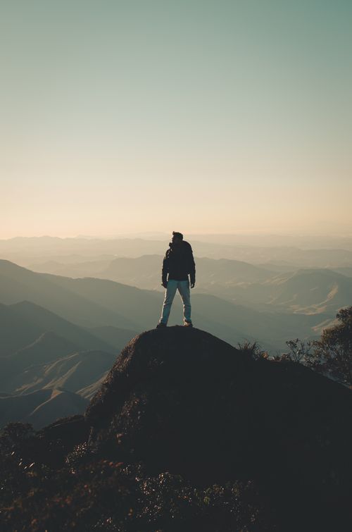 Free A man enjoys a breathtaking view from a mountain peak, embracing freedom and adventure. Stock Photo