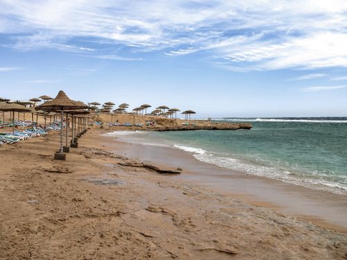 Free Idyllic beach scene in Sharm El-Sheikh, Egypt with clear blue skies and calm sea. Stock Photo
