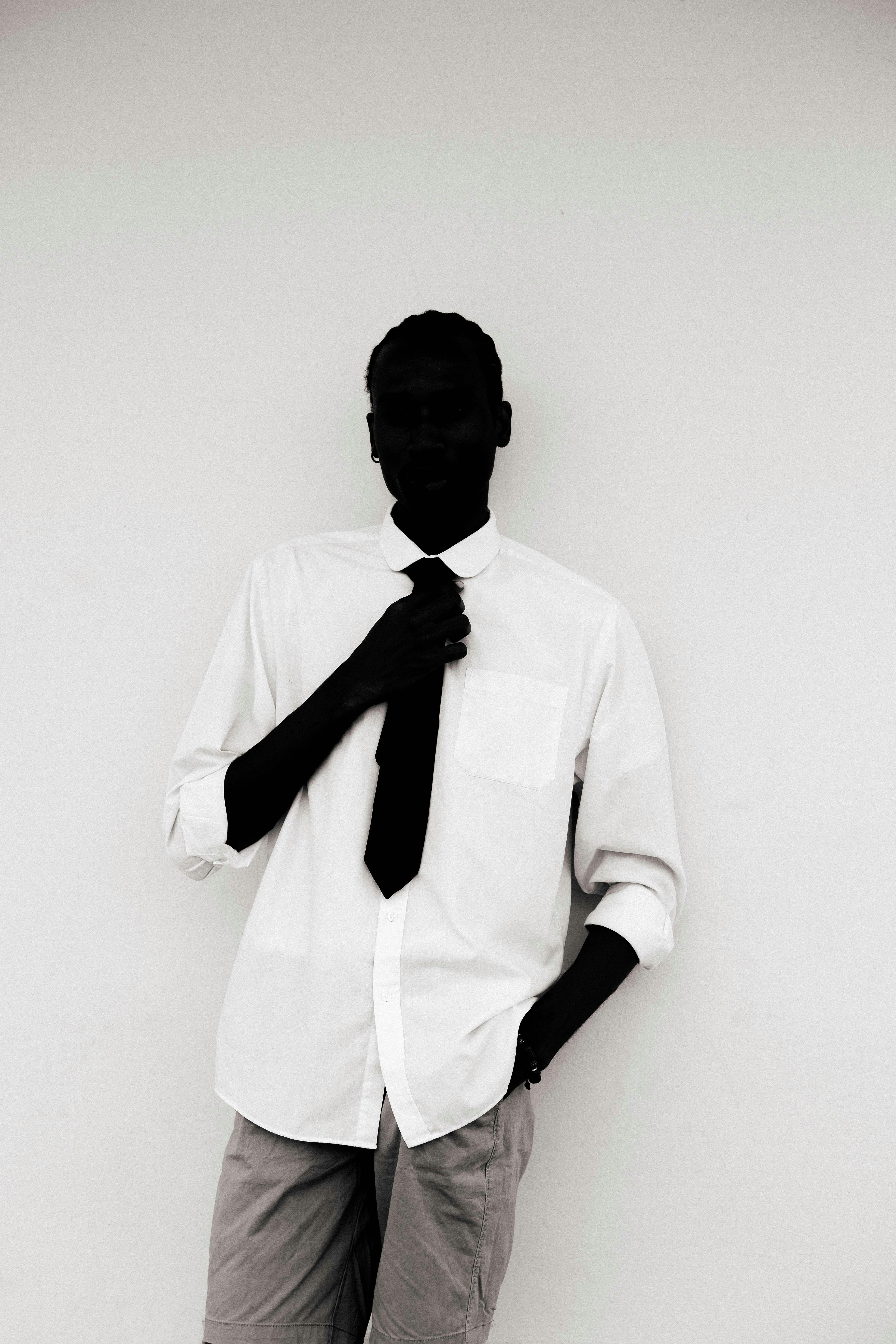 Gratis Kunstnerisk svart-hvitt-portrett av en moteriktig mann med fletter mot en nøytral bakgrunn. Arkivbilde