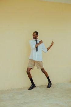 Stylish man with braids poses confidently against a neutral backdrop in Ibadan, Nigeria.