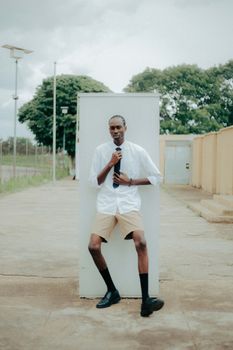 Stylish portrait of a young man in Ibadan, showcasing modern African fashion outdoors.