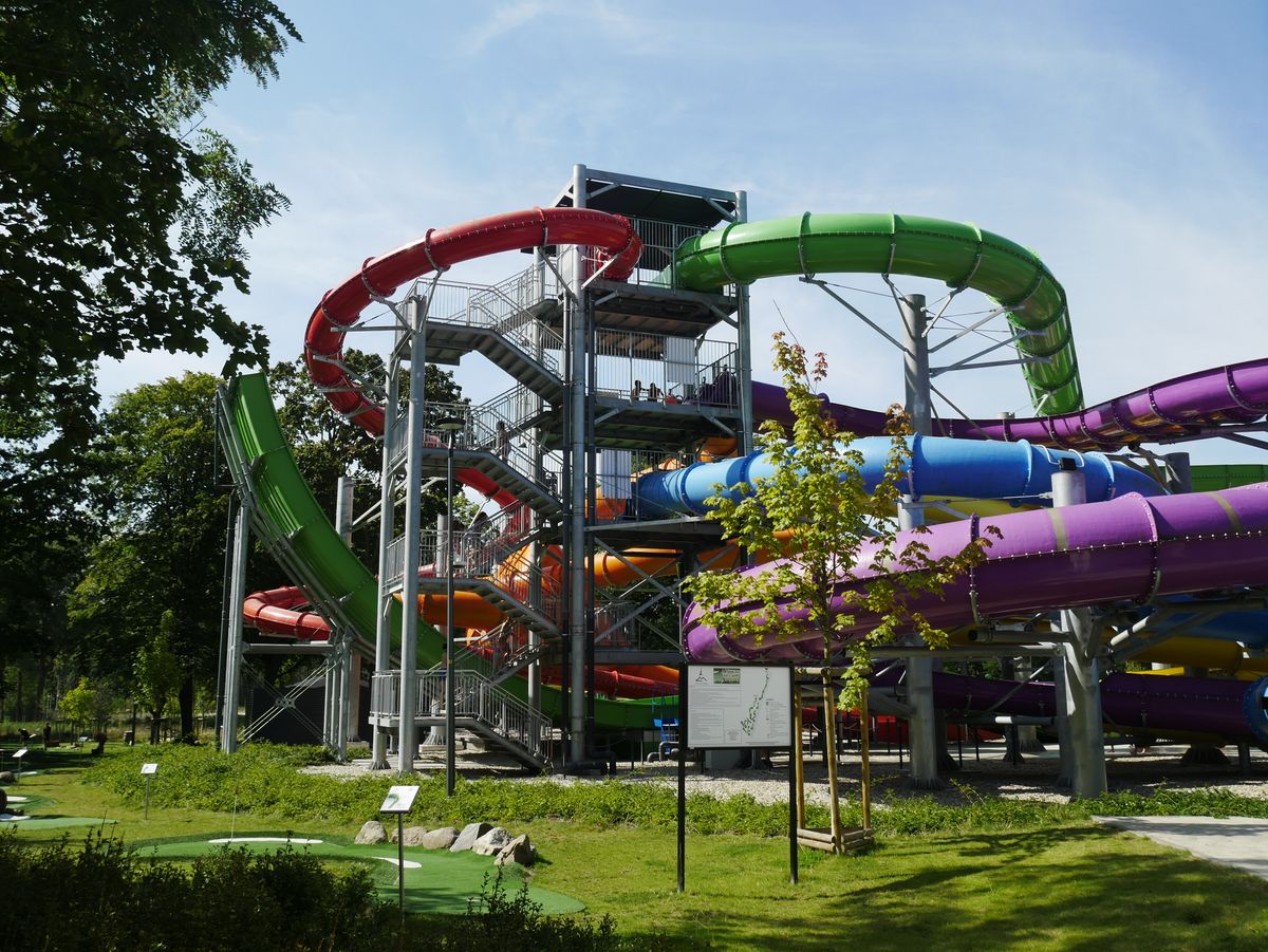 Turn de tobogane colorate al unui complex acvatic din Zielona Góra, Polonia, înconjurat de verdeață