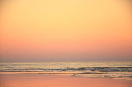 Free Serene view of dawn over the sea at Mar del Plata, Argentina, with soft waves and colorful sky. Stock Photo