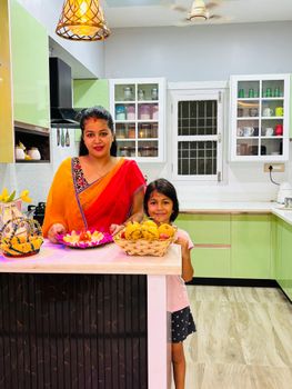 A mother and daughter in a colorful kitchen preparing a festive meal together.