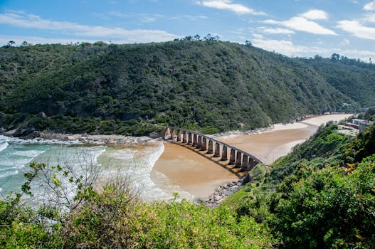 Breathtaking view of the Knysna railway bridge and lush green landscape under clear skies.