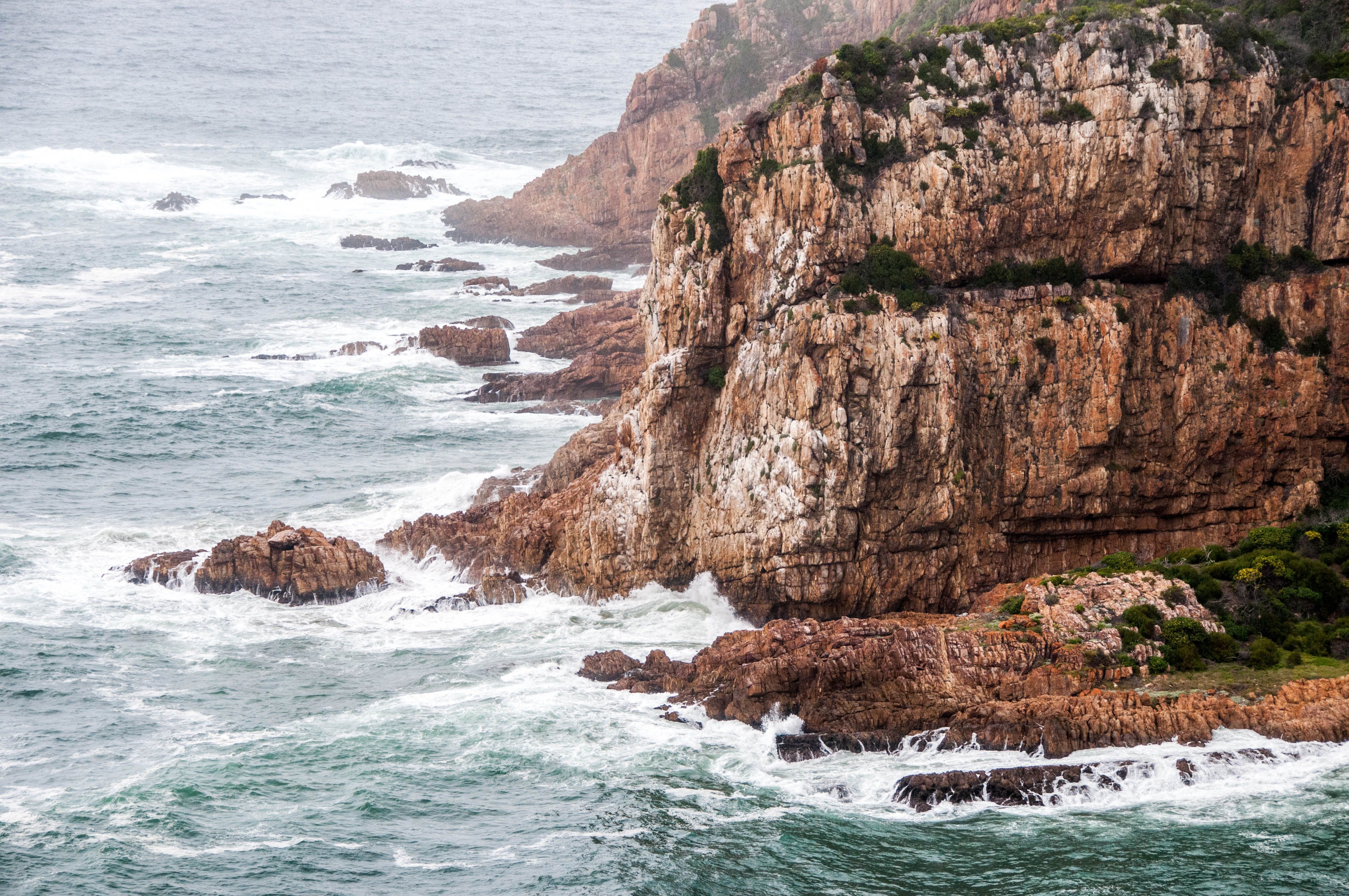 Incredible One Day Cape of Good and Penguin Colony Expedition from Cape Town Review 2026 - Waves crash against the rugged cliffs of the South African shoreline, showcasing nature's raw beauty.