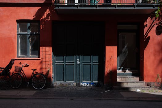 Explore a quaint street in Copenhagen featuring vibrant red walls and parked bicycles.