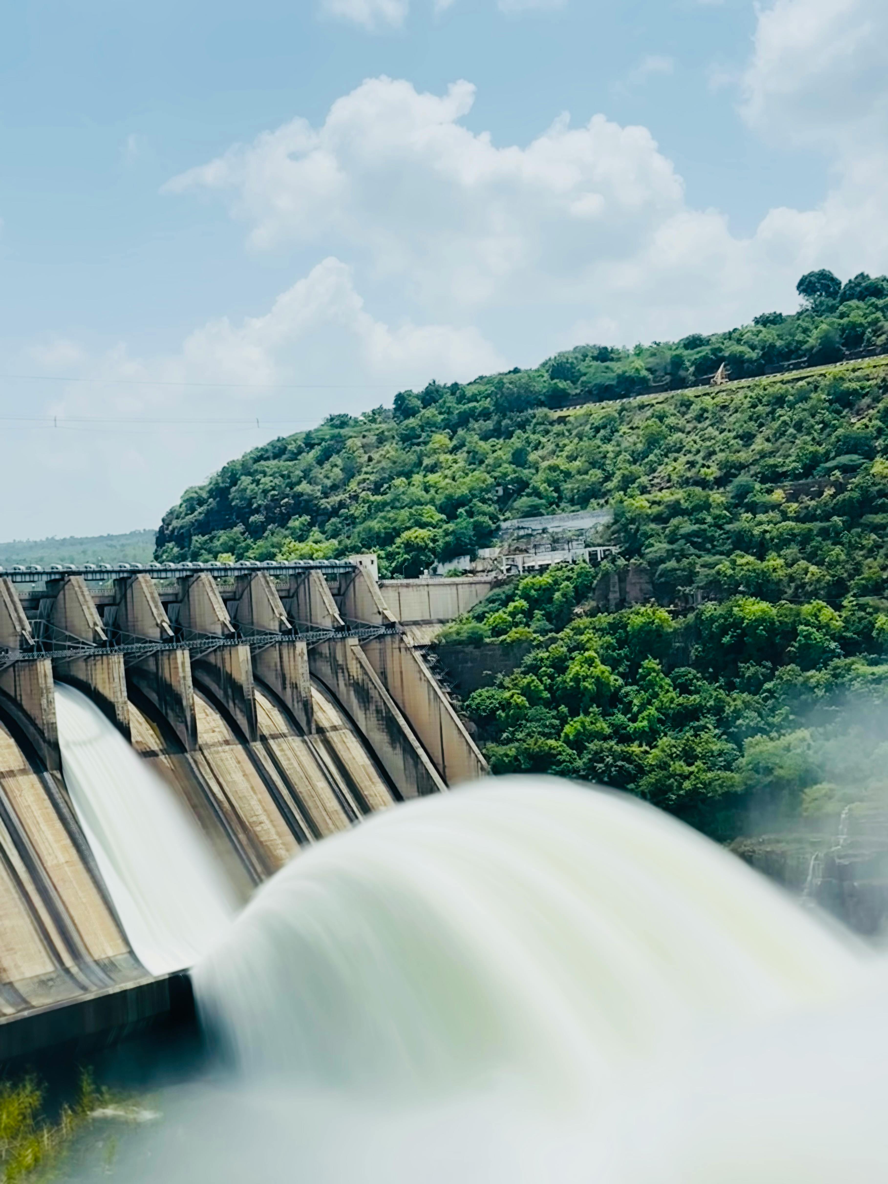 A breathtaking capture of a dam releasing water amidst lush greenery in Andhra Pradesh, India. | Indian Village Development